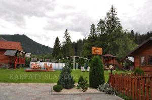 un patio con parque infantil y una casa en Зелена садиба над рікою en Slavske