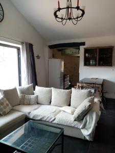sala de estar con sofá blanco y mesa de cristal en La Canopée, en Barret-sur-Meouge