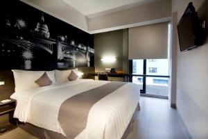 Tempat tidur dalam kamar di Neo Hotel Tendean Jakarta by ASTON