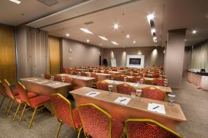 a conference room with tables and chairs and a podium at Neo Hotel Tendean Jakarta by ASTON in Jakarta