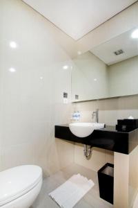 La salle de bains est pourvue d'un lavabo et de toilettes. dans l'établissement Neo Hotel Tendean Jakarta by ASTON, à Jakarta