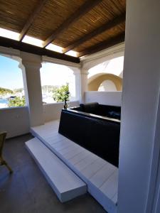 a balcony with a bench and a view of the ocean at Relais Du Port in Santa Teresa Gallura