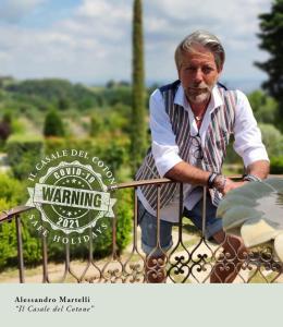 a man sitting on a fence with a sign at Il Casale Del Cotone in San Gimignano