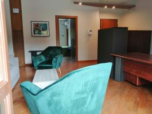 salon z 2 zielonymi krzesłami i biurkiem w obiekcie B&B SALento Garden w mieście Lecce