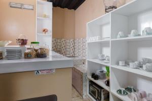 a kitchen with white shelves with dishes on them at Fast Hous Syariah Bogor Mitra RedDoorz in Bogor