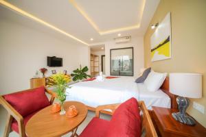 a hotel room with a bed and a table and chairs at Tam Hong Phuc Homestay Hoi An in Hoi An