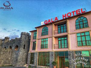 Ruma Qala Hotel في شيكي: مبنى عليه لافتة الفندق