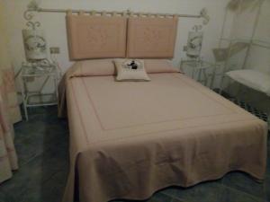 a bedroom with a large bed with a blanket on it at Agriturismo Bachile Bertula in Riola Sardo