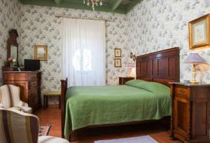 a bedroom with a green bed and a window at Villa Farinella in Viterbo
