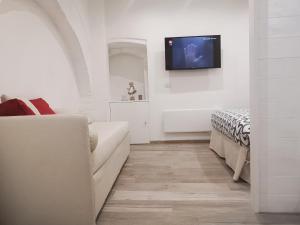 a living room with a couch and a tv on a wall at Dimora San Francesco in Bevagna