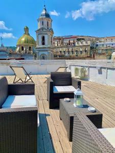 a rooftop patio with chairs and tables and a building at B&B Belvedere Partenopeo in Naples