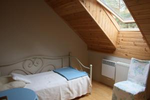 a bedroom with a bed and a window and a chair at Całoroczny dom wakacyjny Kotkowo 93 in Kotkowo