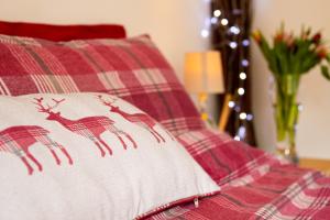 un oreiller rouge et blanc avec trois cerfs dessus dans l'établissement The Mills Guesthouse Hatfield, à Hatfield