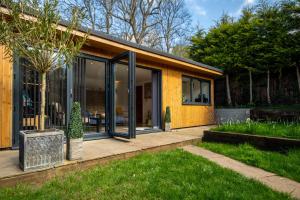 a yellow house with glass doors and a garden at The Mills Guesthouse in Hatfield