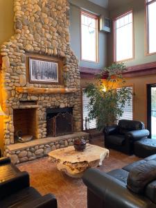 a living room with a large stone fireplace at Elkwater Lake Lodge and Resort in Elkwater