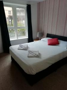 a bedroom with a large bed with two towels on it at Wallace Hide Out in Glasgow