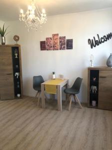 a dining room with a table and chairs and a chandelier at Marktblick in Norden