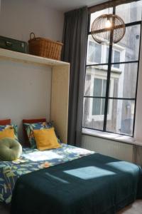 a bedroom with a bed in front of a window at Steeg 8 in Dordrecht