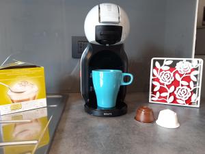 a coffee maker sitting on a counter with a blue cup at Appartamento la Terrazza in Arco