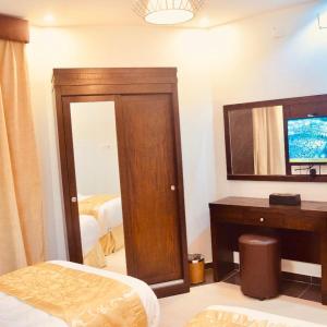Schlafzimmer mit einem Bett, einem Spiegel und einem Schreibtisch in der Unterkunft شاليهات رميس للعائلات RAMIS Chalet in Abha