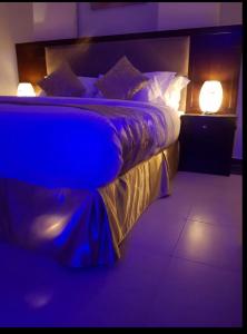 een slaapkamer met een bed met twee verlichting bij شاليهات رميس للعائلات RAMIS Chalet in Abha