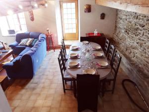 a dining room with a table and a blue couch at Le Pijoulet in Tignac