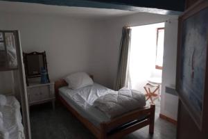niewielka sypialnia z łóżkiem i oknem w obiekcie Maison Bretagne proche Penestin port La Roche Bernard 5 à 6 pers w mieście La Roche-Bernard