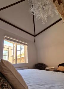 a bedroom with a white bed and a window at Appartement Mes Amis Delft in Delft