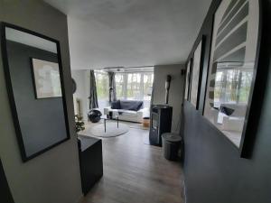 a hallway with a living room with a couch at La pinède - Charmante maison de village in Hotton