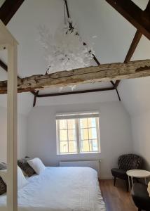 a bedroom with a white bed and a window at Appartement Mes Amis Delft in Delft