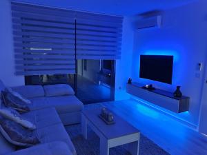 a blue living room with a couch and a tv at Moderno Duplex Comfort in Roses