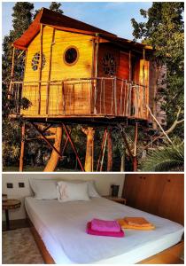 a tree house with a bed in front of it at Dream catcher treehouse in Preveza