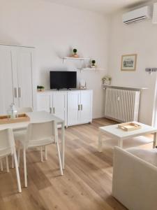 sala de estar con mesa blanca y sillas en Casa Teo Pavia città, en Pavia