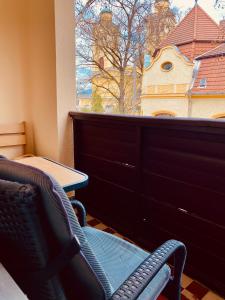 Un balcón con dos sillas y una mesa y una ventana. en Victoria Apartman, en Eger