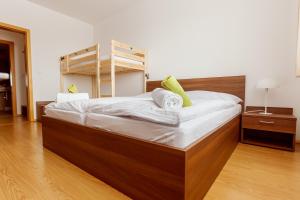 una camera con un grande letto con testiera in legno di Ski IN-OUT Apartmán Donovaly a Donovaly