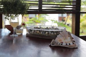 a table with a glass of wine and a tray of shells at Pousada Vettore in Atins +23 photos