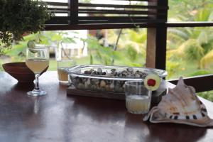 a table with a tray of food and a glass of wine at Pousada Vettore in Atins