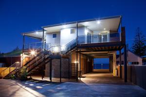 a house with a staircase leading up to it at night at Penguin Waterfront Escape in Penguin