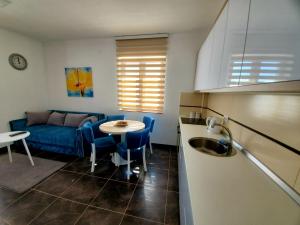 a kitchen with a table and a blue couch at Zlatibor Hills Royal in Zlatibor