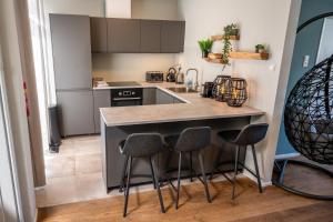 a kitchen with a counter and stools in it at Beach House Makai - family house with Finnish Sauna, 2 bathrooms and only minutes from the Beach in De Koog