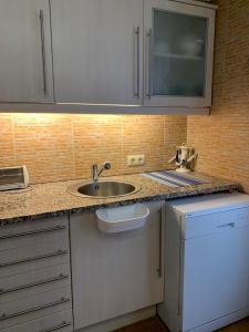 uma cozinha com um lavatório e uma bancada em CASA la PAU em Vilassar de Mar