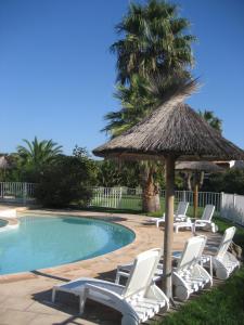 a group of chairs and an umbrella and a swimming pool at Liflosa in Lecci
