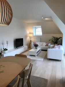 a living room with white furniture and a table at EastDune in Oostduinkerke