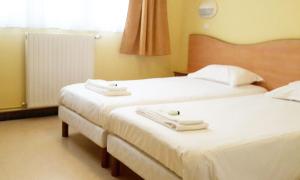 2 bedden in een hotelkamer met witte lakens bij Stella Maris in Stella-Plage