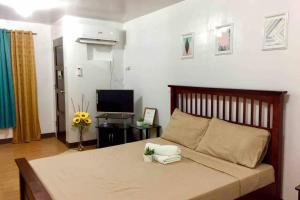 a bedroom with a large bed and a television at AFFORDABLE BUDGET FRIENDLY STUDIO UNIT in Cebu City