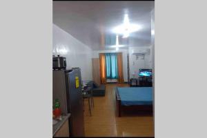a kitchen and living room with a refrigerator and a table at AFFORDABLE BUDGET FRIENDLY STUDIO UNIT in Cebu City