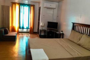 a living room with a large bed and a television at AFFORDABLE BUDGET FRIENDLY STUDIO UNIT in Cebu City
