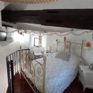 1 dormitorio con cama blanca y mesa en Moinho da Amélia, en Cadaval
