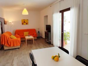 un salon avec un canapé orange et une table dans l'établissement Casa el Patio del Limón, con piscina, à Montecorto