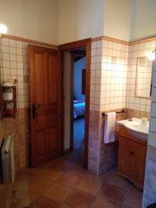 a bathroom with a toilet and a sink and a door at Casa Llayo in Aliezo